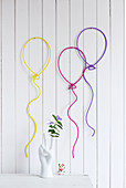 Wall decorations shaped like balloons made from wire and knitted tubes