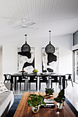 Table and chairs in black in the open living room with high ceiling