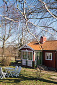 Falu-red Swedish house with conservatory and garden in spring