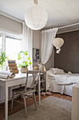 Desk below window in child's bedroom decorated in white and grey