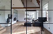 View through glass and steel wall into minimalist living room