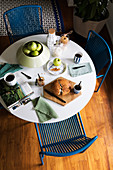 Table set for simple breakfast and blue chairs
