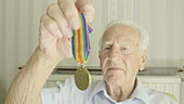 Senior man holding war medal