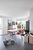 Vilac ride-on car in open-plan dining area with orange designer chairs