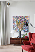 Designer lamp on low sideboard below artwork with rectangles of colour