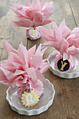 Decorative place cards with napkin flowers and initials made from modelling clay