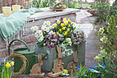 Easter terrace: wooden box with primroses, daffodils, moss saxifrage, milk star and thick leaf 'Desert Diamond', wooden Easter bunnies and Easter eggs