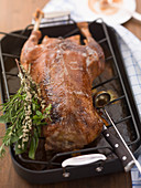 A whole roast goose with a bouquet of herbs
