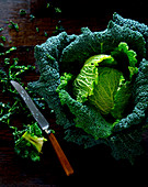 Savoy cabbage, partially sliced, with a knife