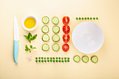 Gurken, Tomaten, Erbsen und Kräuter als Zutaten für vegetarische Gerichte