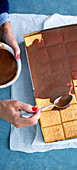 Schoko-Pudding-Kuchen mit Butterkeksen wird mit Kuvertüre überzogen