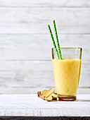 A yellow smoothie with mango, orange, pineapple and ginger