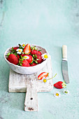 Strawberries in a bowl with daisies flowers