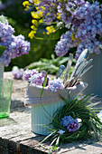 Cutlery in pot with lilac blossoms and wreaths made from grass