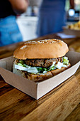 Burger in Take-Away-Box auf Restauranttheke