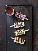 Mango, pistachio, vanilla and raspberry ice cream on sticks with chocolate