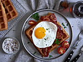 Buttermilk waffles with fried egg and maple syrup (USA)