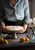 Lemon tart with meringue topping on a cake stand