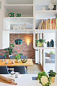 Suspended shelving used as partition between kitchen and dining room