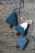 Knitted winter decorations in shapes of fir trees on rustic wood