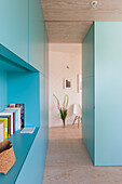 Room with turquoise-colored fitted wardrobes and hallway to the dining room