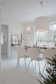 Set table in white dining room decorated for Christmas