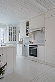 White, Scandinavian-style country-house kitchen with wooden floor