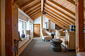 Rustic living room under sloping, wood-clad ceiling