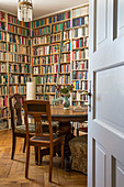 View of antique pedestal table in library seen through open panelled door