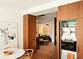 Fitted kitchen with wooden fronts and round marble table with classic chairs