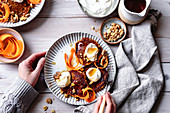 Gluten-free carrot cake pancakes with carrot ribbons, yogurt, maple syrup and walnuts.