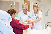 Nurse and trainee checking on a patient