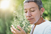 Woman enjoying the scent of rosemary