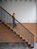 Blurred woman walking down cantilever stairs