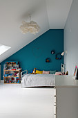 Kinderzimmer im Dachgeschoß mit türkisblauer Wand