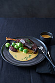 Glazed goose leg with apple compote and Brussels sprouts