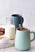 Mugs of white and black coffee with date cookies.