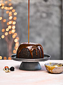 Karamellsauce fließt auf jamaikanischen Sponge Pudding (Weihnachten)