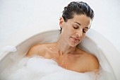 Serene woman enjoying bubble bath
