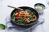 Vegan Schupfnudeln with spinach and strawberry salad and herb dressing
