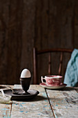 Frühstücksei in Eierbecher auf rustikalem Holztisch