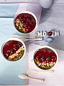 Smoothie bowls with cherries, cereals and pistachio nuts