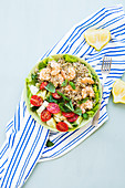 Leichte glutenfreie Sommer Bowl mit Buchweizen, Gurken, Tomaten und Garnelen auf Salatblättern