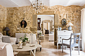 French travertine floors, bureau, stone walls and seating area in living room