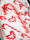 Candy canes in different sizes on powdered sugar