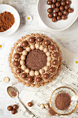Overhead view of a chocolate cake decorated with piped buttercream and chocolate malt balls