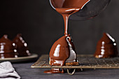 Ein Baisertörtchen mit Schokolade überziehen