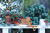 Metal angle, teaberry and wreath on table outside
