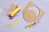 Craft utensils for making lion's head: metal ring, raffia and cardboard