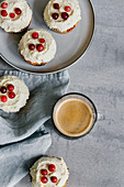 Cupcakes wit classic cream-cheese frosting with cranberries and coffee
